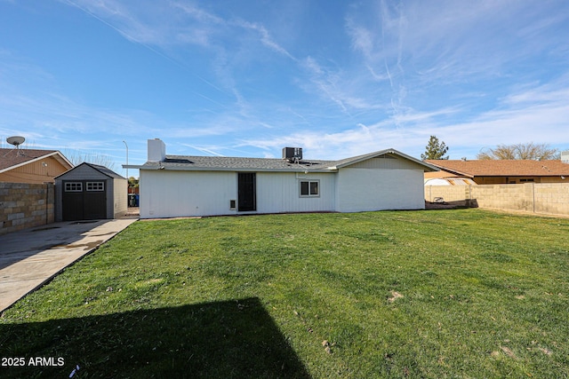 back of house featuring cooling unit, a shed, and a lawn