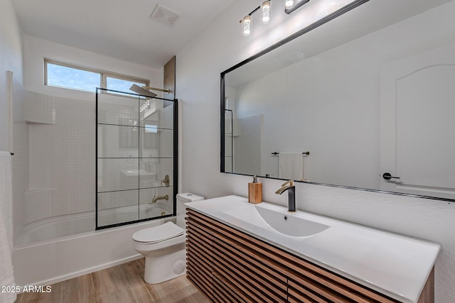 full bath with visible vents, toilet, wood finished floors, tub / shower combination, and vanity