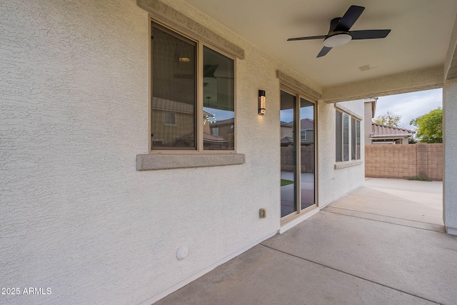 view of patio / terrace with ceiling fan and fence