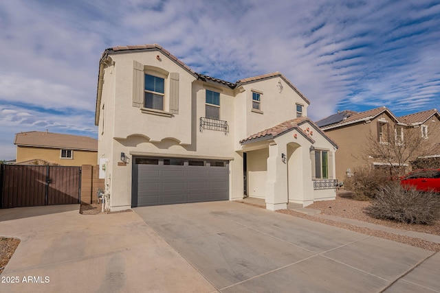 mediterranean / spanish-style home with concrete driveway, a tile roof, an attached garage, a gate, and stucco siding