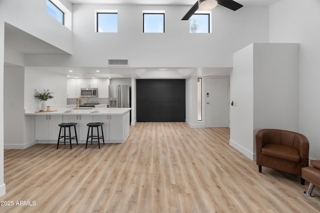 2935 N 68th St Unit 205, Scottsdale, AZ 85251 - living area featuring a towering ceiling, ceiling fan, and light wood-type flooring