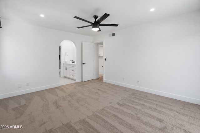 2935 N 68th St Unit 205, Scottsdale, AZ 85251 - unfurnished bedroom with arched walkways, light carpet, recessed lighting, connected bathroom, and a ceiling fan
