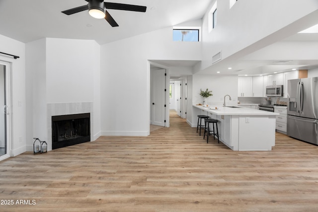2935 N 68th St Unit 205, Scottsdale, AZ 85251 - kitchen featuring appliances with stainless steel finishes, a kitchen breakfast bar, a peninsula, ceiling fan, and white cabinets