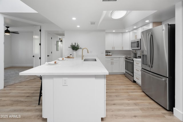 2935 N 68th St Unit 205, Scottsdale, AZ 85251 - kitchen featuring appliances with stainless steel finishes, a breakfast bar area, recessed lighting, white cabinetry, and ceiling fan