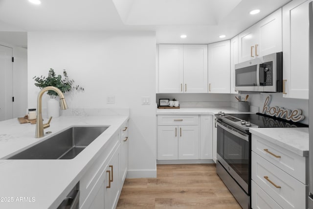 2935 N 68th St Unit 205, Scottsdale, AZ 85251 - kitchen featuring appliances with stainless steel finishes, recessed lighting, light wood finished floors, white cabinetry, and light stone counters