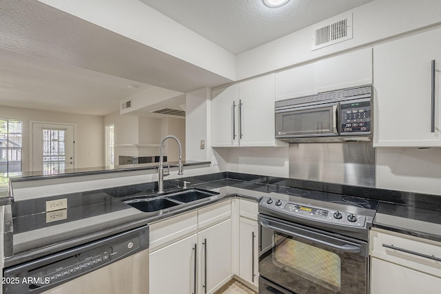 2333 E Southern Ave Unit 1023, Tempe, AZ 85282 - kitchen featuring appliances with stainless steel finishes, white cabinets, dark countertops, and a textured ceiling
