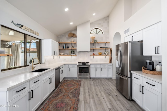 kitchen featuring stainless steel appliances, light hardwood / wood-style flooring, sink, backsplash, and white cabinets