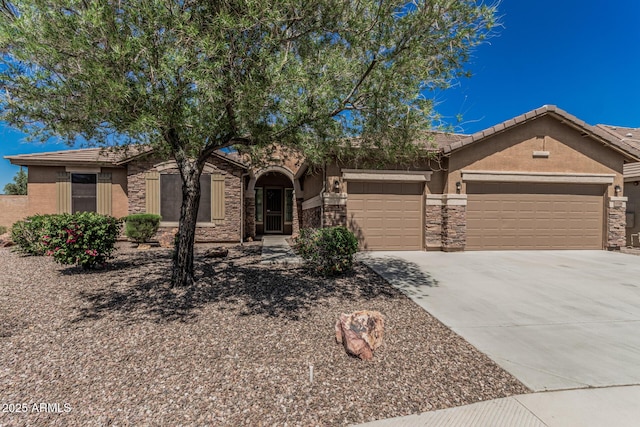view of front of property featuring concrete driveway, stone siding, stucco siding, and a garage