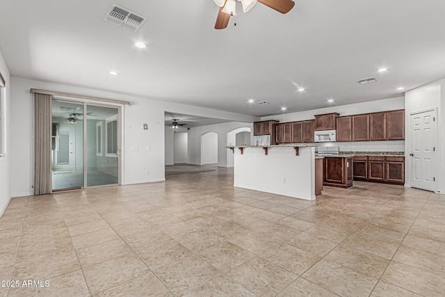 kitchen featuring a kitchen island, visible vents, a ceiling fan, and white microwave