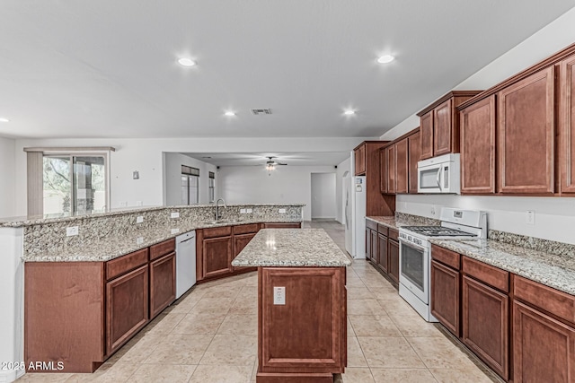 kitchen with recessed lighting, a large island, a sink, and white appliances