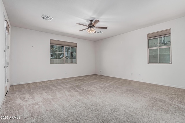 carpeted empty room featuring baseboards, visible vents, a ceiling fan, and a wealth of natural light