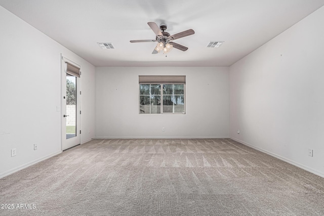 carpeted empty room featuring baseboards, a ceiling fan, and visible vents