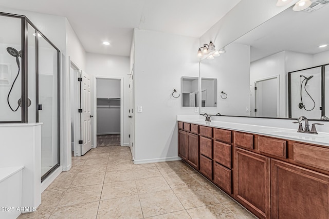 bathroom featuring tile patterned floors, a sink, a shower stall, and double vanity