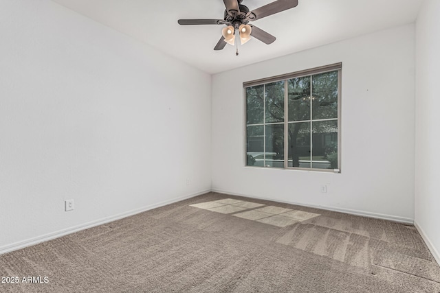 carpeted empty room featuring ceiling fan and baseboards