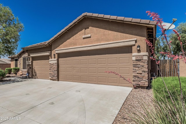 ranch-style house featuring stucco siding, fence, stone siding, and a garage