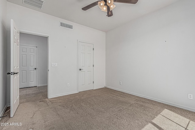 unfurnished bedroom featuring baseboards, visible vents, and carpet