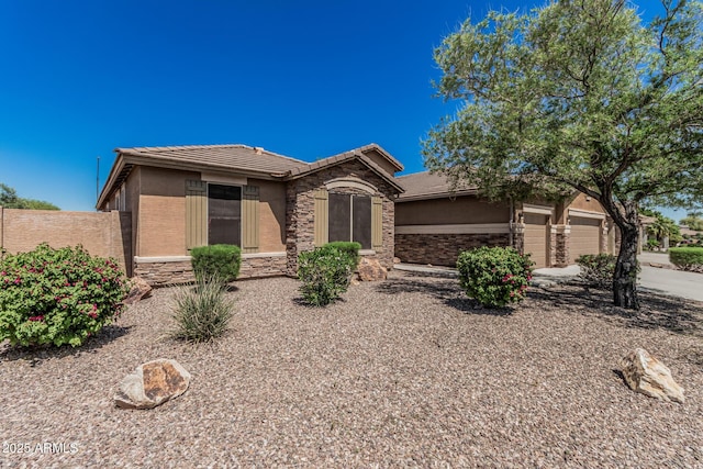 view of front of property featuring a tiled roof, stone siding, concrete driveway, an attached garage, and stucco siding