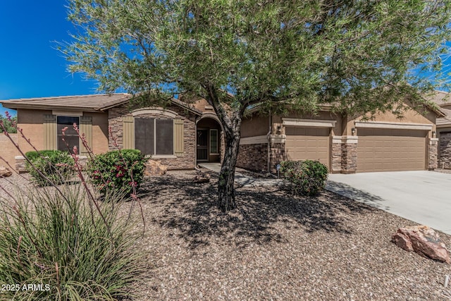 view of front of home with stucco siding, stone siding, concrete driveway, and a garage