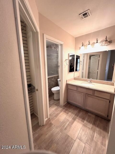 bathroom featuring hardwood / wood-style floors, vanity, and toilet