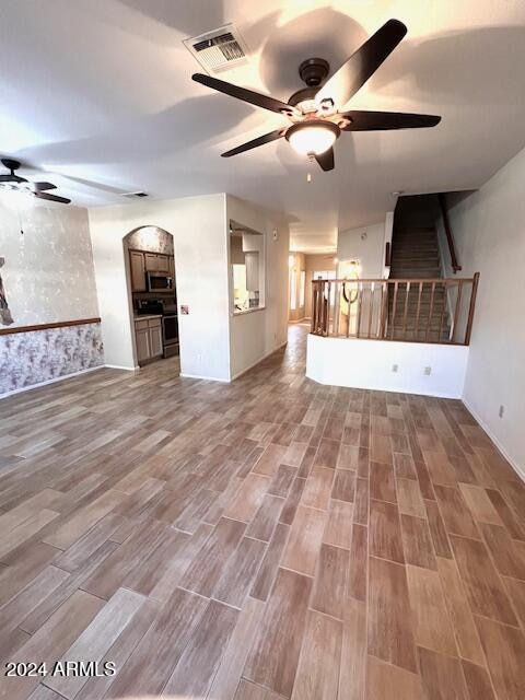 unfurnished living room featuring ceiling fan and wood-type flooring