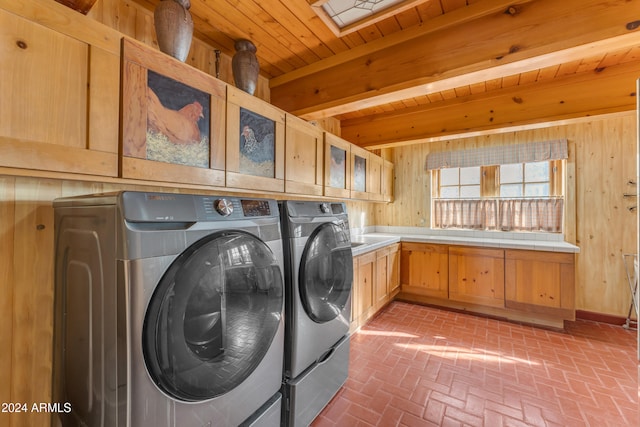 washroom with wooden ceiling, wood walls, brick floor, and washing machine and clothes dryer