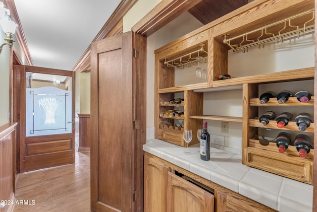 wine area featuring wainscoting and light wood-style floors