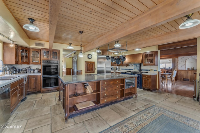 kitchen featuring open shelves, tasteful backsplash, visible vents, a kitchen island with sink, and built in appliances