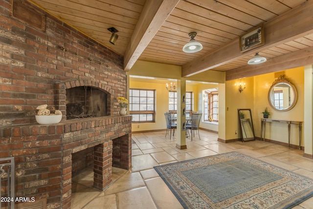 living area with beam ceiling, a fireplace, a chandelier, wooden ceiling, and baseboards