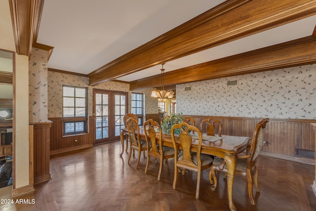 dining room with wallpapered walls, wainscoting, crown molding, a chandelier, and beam ceiling