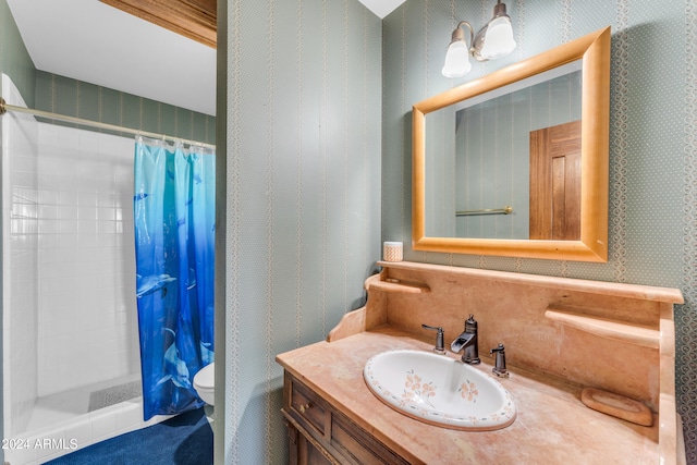 full bath featuring a tile shower, vanity, toilet, and wallpapered walls