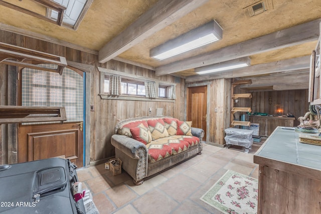 interior space with beam ceiling, visible vents, and wooden walls