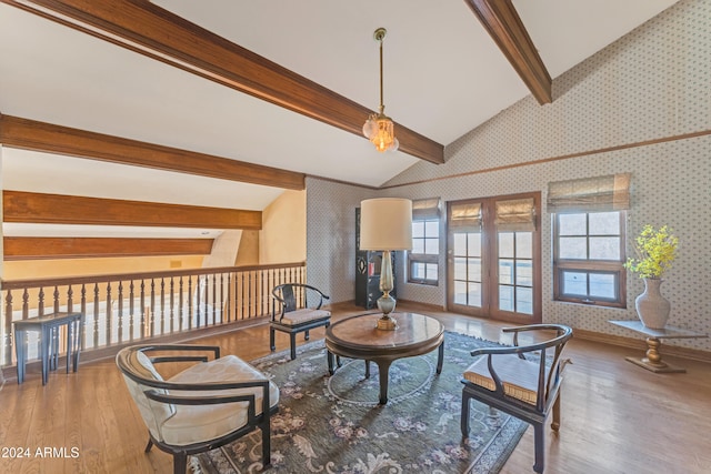 living area with wallpapered walls, baseboards, wood finished floors, vaulted ceiling with beams, and french doors