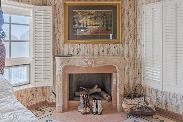 room details featuring a fireplace, baseboards, and wallpapered walls