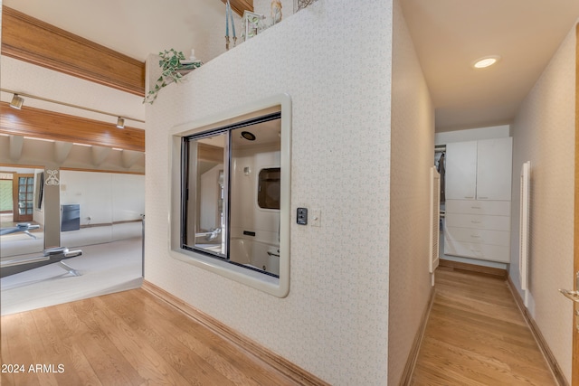 hallway featuring wallpapered walls, baseboards, and wood finished floors