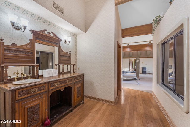 bathroom with baseboards, wood-type flooring, visible vents, and wallpapered walls