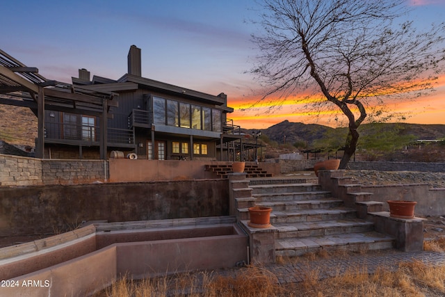 back of property with a chimney and stairs