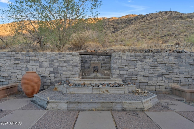 view of patio / terrace with a mountain view and an outdoor stone fireplace