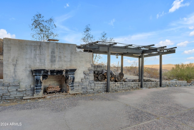 view of patio with a pergola and an outdoor fireplace