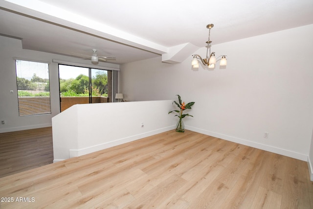 5122 E Shea Blvd Unit 1043, Scottsdale, AZ 85254 - spare room featuring a chandelier, baseboards, and wood finished floors