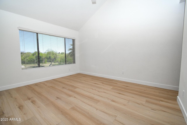 5122 E Shea Blvd Unit 1043, Scottsdale, AZ 85254 - empty room featuring light wood-style flooring, lofted ceiling, and baseboards