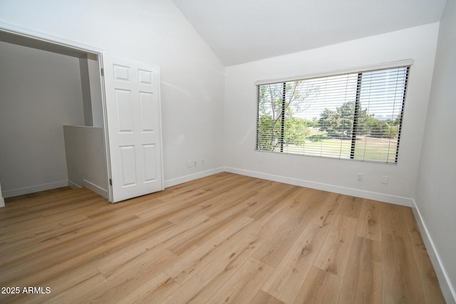 5122 E Shea Blvd Unit 1043, Scottsdale, AZ 85254 - spare room featuring lofted ceiling, light wood-style flooring, and baseboards