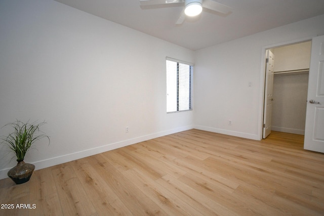 5122 E Shea Blvd Unit 1043, Scottsdale, AZ 85254 - unfurnished bedroom with light wood-type flooring, baseboards, a spacious closet, and a ceiling fan