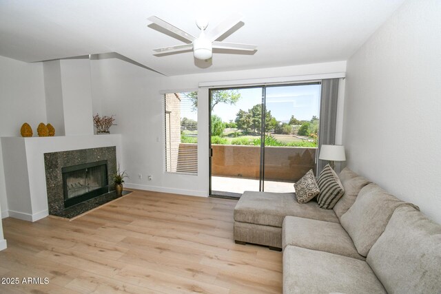5122 E Shea Blvd Unit 1043, Scottsdale, AZ 85254 - living area with light wood-style floors, ceiling fan, a high end fireplace, and baseboards