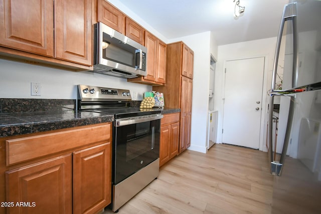 5122 E Shea Blvd Unit 1043, Scottsdale, AZ 85254 - kitchen with appliances with stainless steel finishes, light wood-style floors, brown cabinets, and tile counters