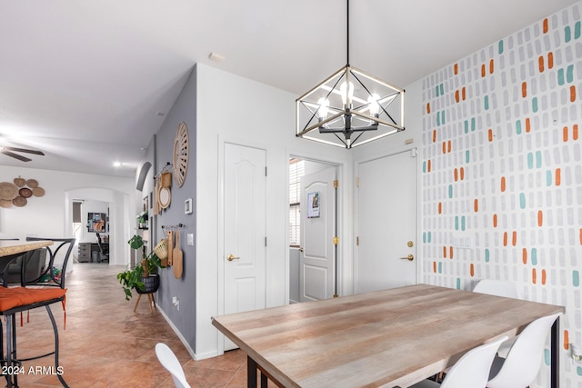 dining space featuring light tile patterned floors, baseboards, arched walkways, and a notable chandelier