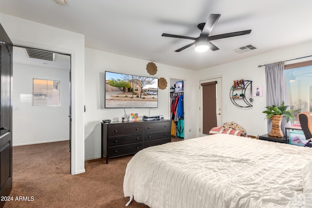 bedroom with baseboards, visible vents, ceiling fan, a spacious closet, and dark colored carpet