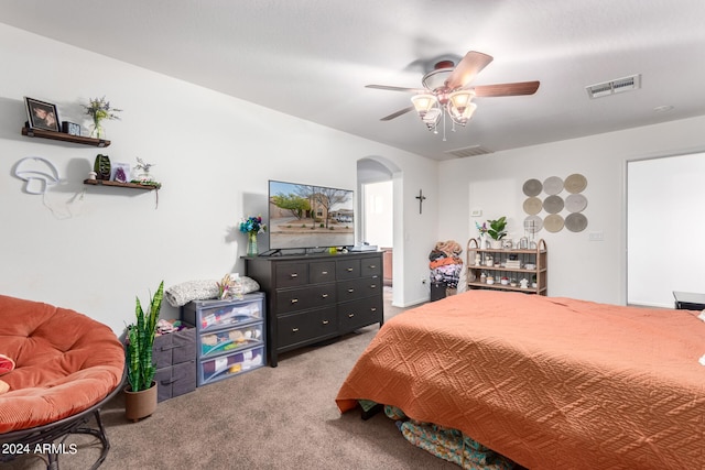 bedroom featuring arched walkways, carpet floors, ceiling fan, and visible vents