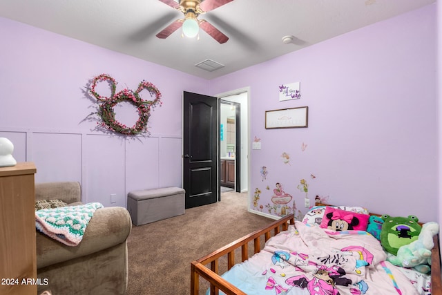 bedroom with a decorative wall, carpet floors, visible vents, a ceiling fan, and wainscoting