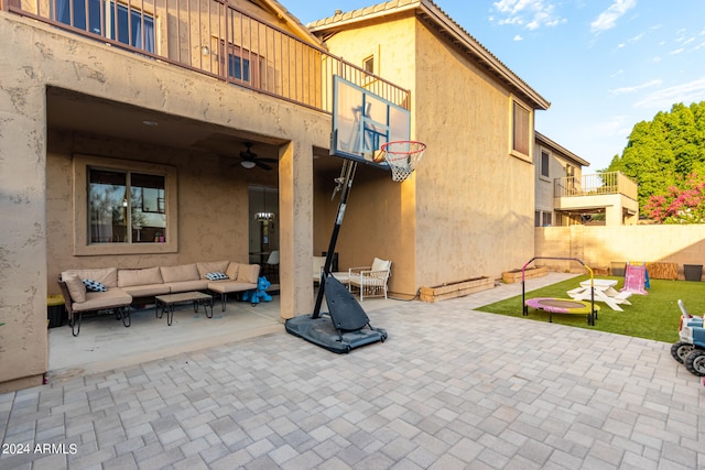 view of patio with fence, ceiling fan, a balcony, and an outdoor hangout area