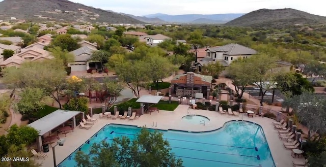 pool featuring a residential view, a mountain view, fence, and a patio